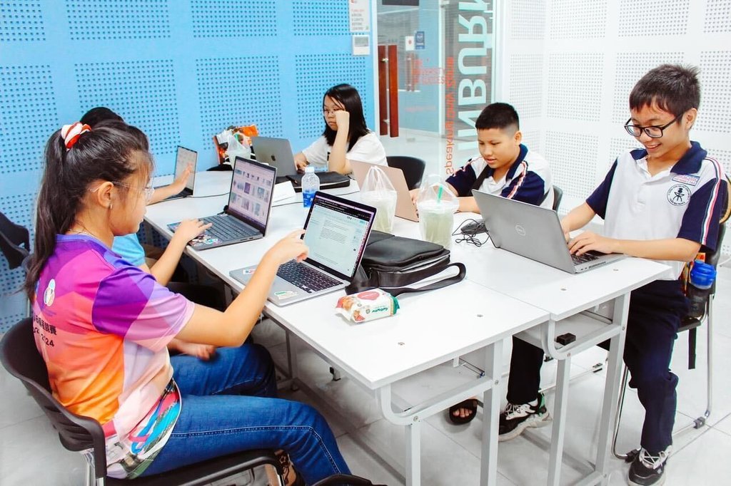 Students work on computers around a table
