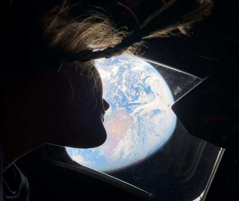 NASA Astronaut Christina Koch looking out the window at Earth.